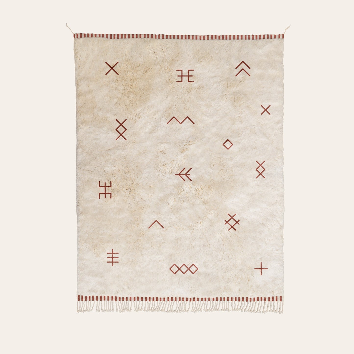 Natural wool rug with geometric patterns in maroon on a white background
