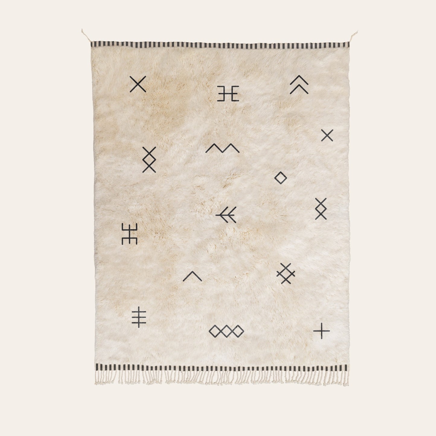 Natural wool rug with geometric patterns in black on a white background