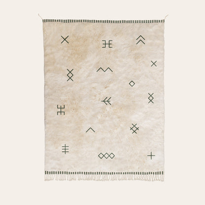 Natural wool rug with geometric patterns in forest green on a white background